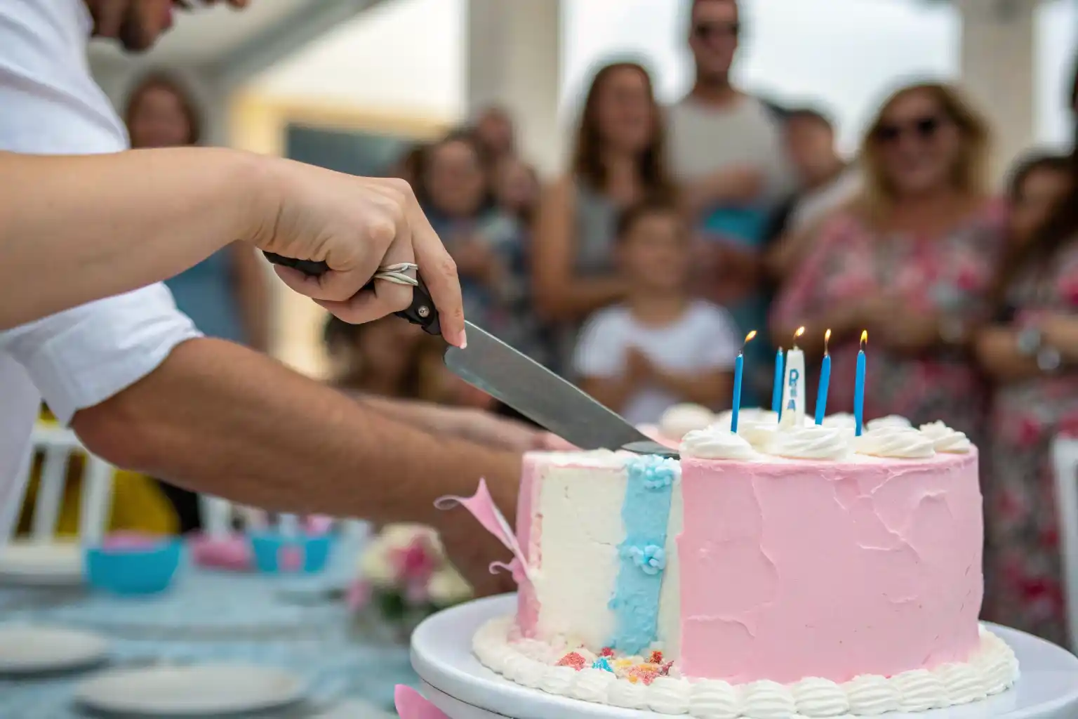 Cutting a gender reveal cake to reveal the surprise pink or blue center.